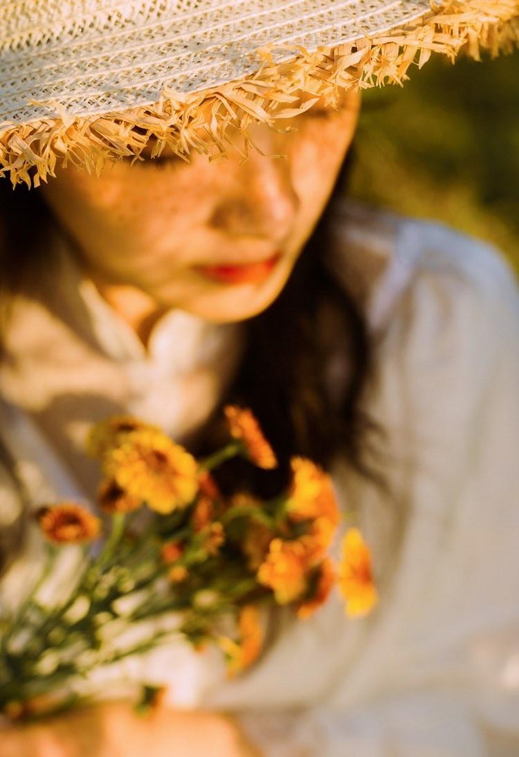 文藝美女潔白長裙?jié)饷芫戆l(fā)手捧鮮花叢林寫真圖片