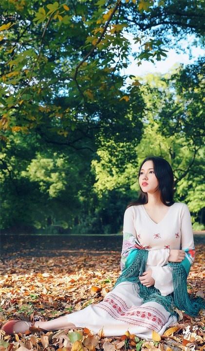 大樹下清純靈動美女手捧蘋果纖細(xì)身形圖片