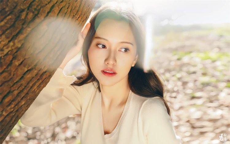 大樹下清純靈動美女手捧蘋果纖細(xì)身形圖片