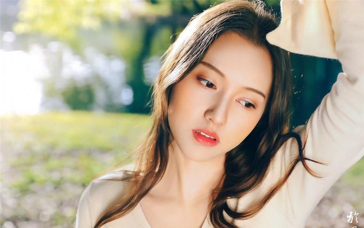 大樹下清純靈動美女手捧蘋果纖細(xì)身形圖片