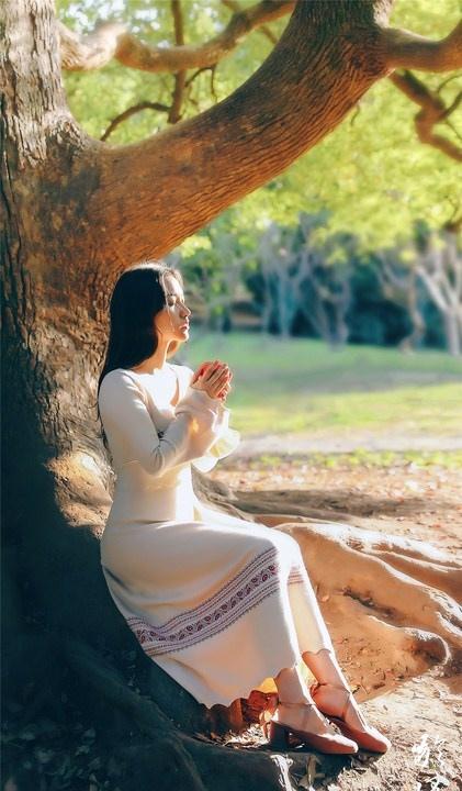 大樹下清純靈動美女手捧蘋果纖細(xì)身形圖片