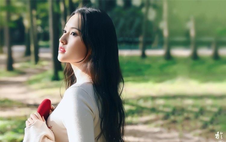 大樹下清純靈動美女手捧蘋果纖細(xì)身形圖片