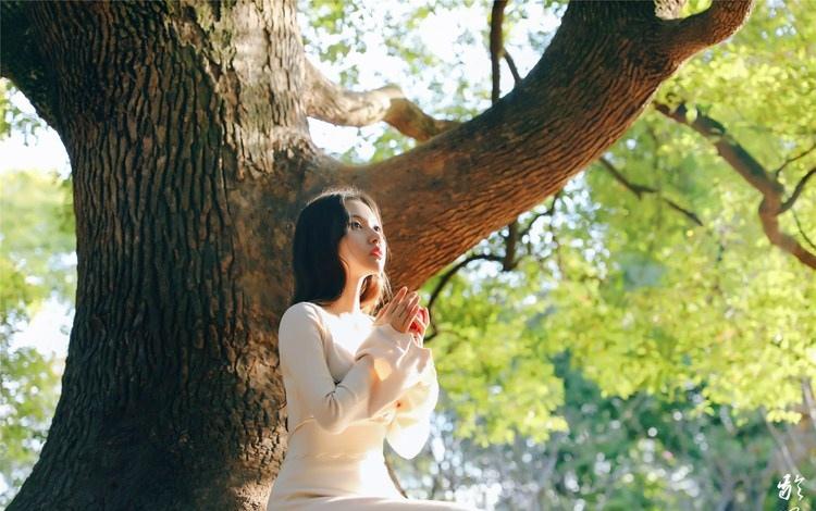 大樹下清純靈動美女手捧蘋果纖細(xì)身形圖片